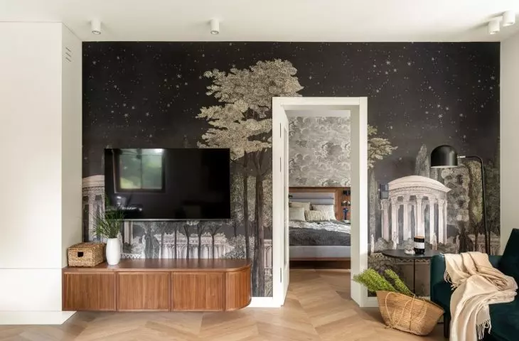 The wall in the living area has been decorated with wallpaper with a night city motif