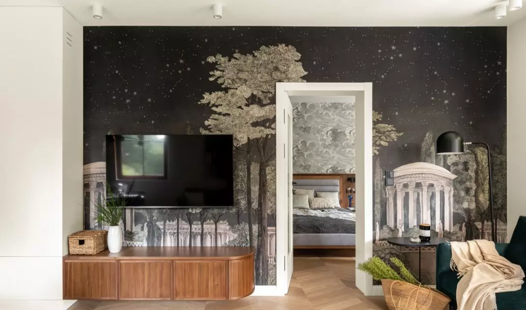 The wall in the living area has been decorated with wallpaper with a night city motif