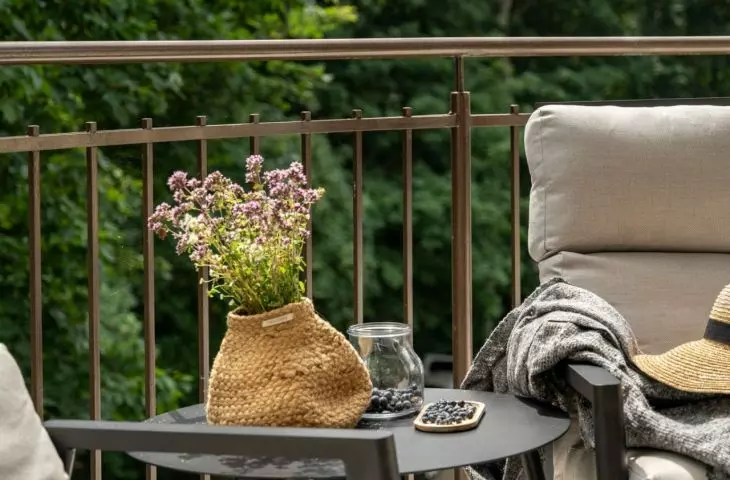 Two comfortable armchairs and a practical table create a space to enjoy time outdoors