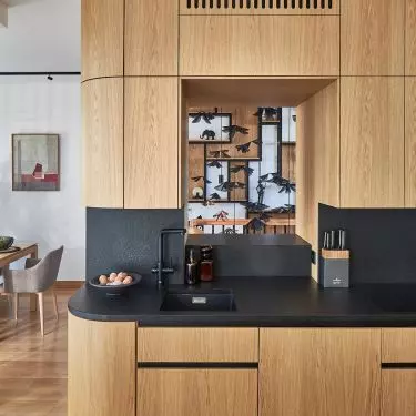 The kitchen is distinguished by built-ins with a clearance over the hob, which optically opens up the space and gives it lightness