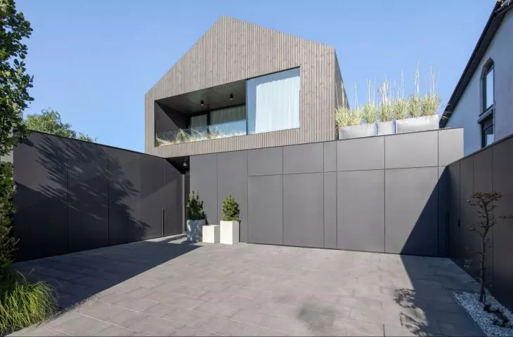 The facade harmoniously combines two contrasting materials - natural wood and modern facade panels