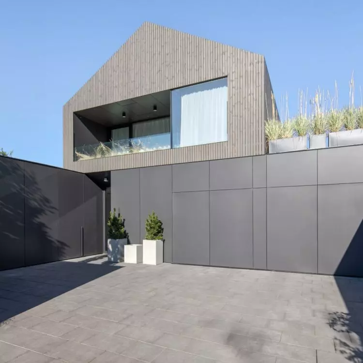 The facade harmoniously combines two contrasting materials - natural wood and modern facade panels