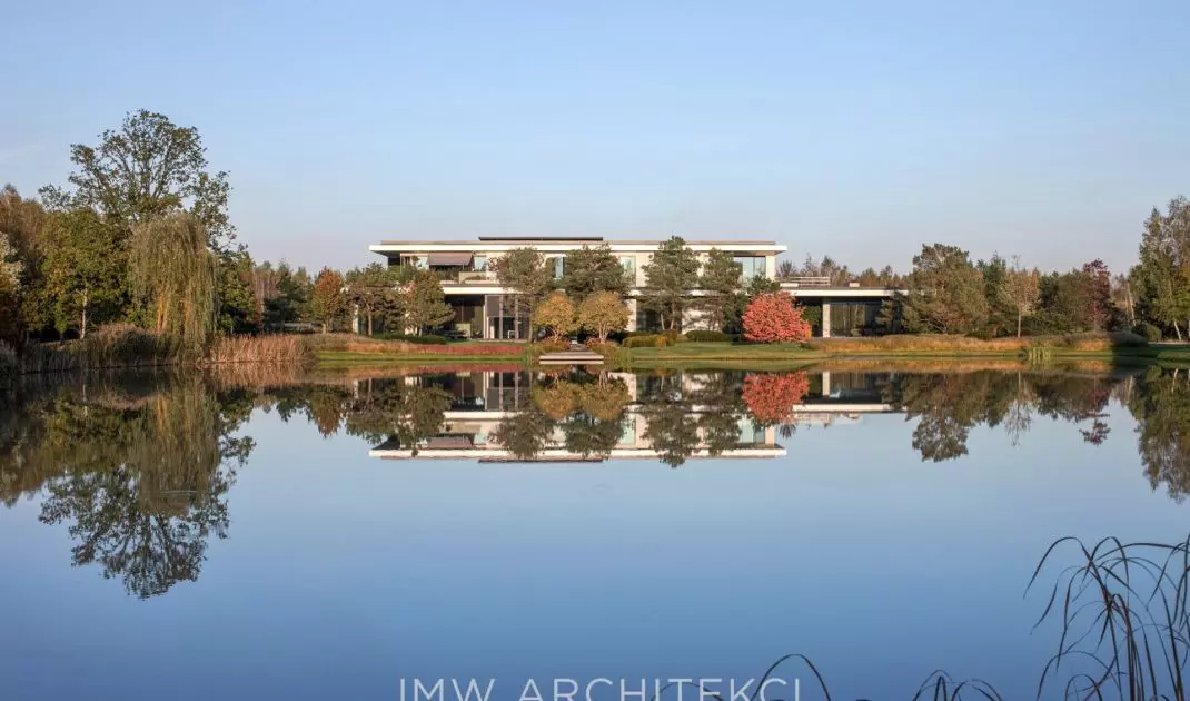 Lakefront Residence jest usytuowana bezpośrednio nad wodą, co sprawia, że tafla stawu odbija bryłę budynku, otaczającą roślinność i niebo