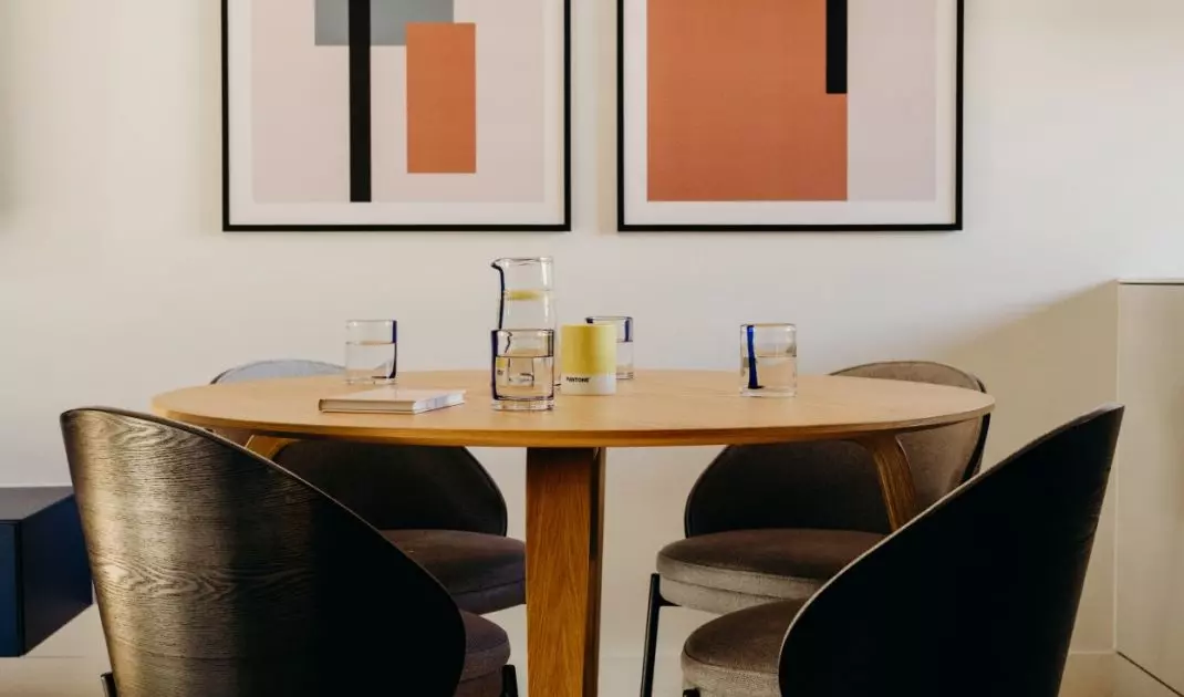Above the table in the dining area hangs a designer lamp resembling a cloud