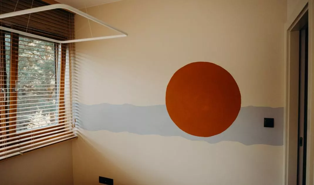 Ścianę naprzeciwko łóżka zdobi mural