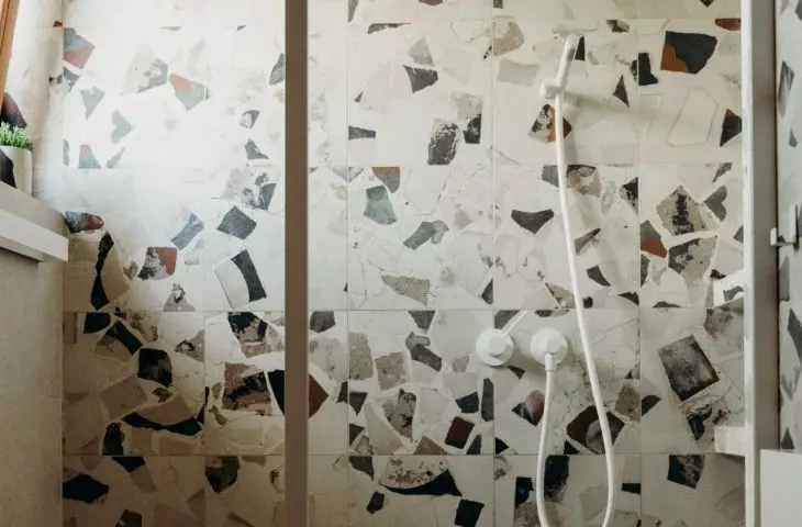 The bathroom uses patterned terazzo tiles