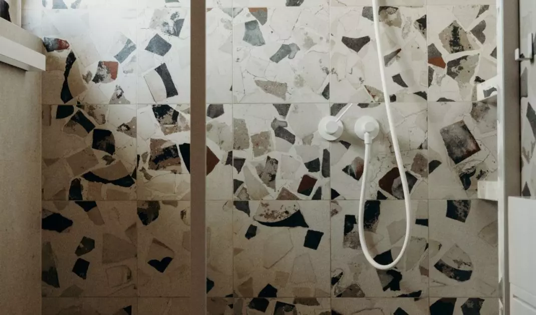 The bathroom uses patterned terazzo tiles