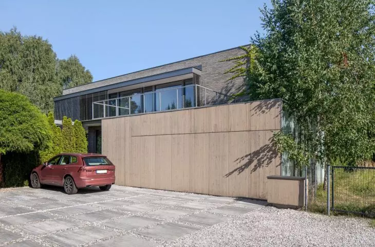 The facade was finished with brick in shades of gray, light wood and milk glass