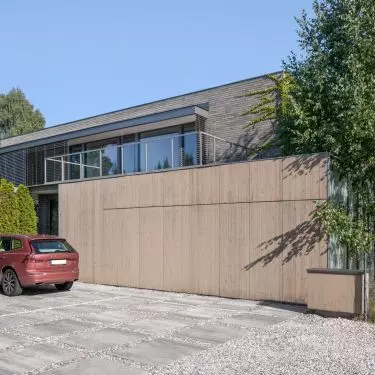 The facade was finished with brick in shades of gray, light wood and milk glass