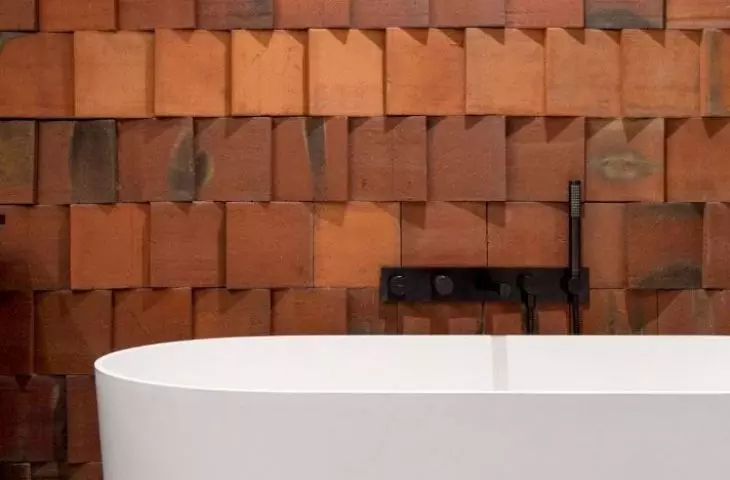 The upstairs bathroom has a brick wall