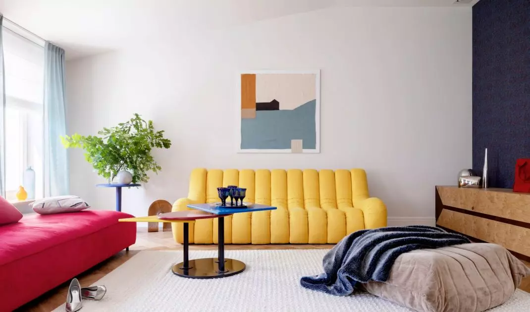 In the living room, the architect put together a yellow sofa and a red chaise longue