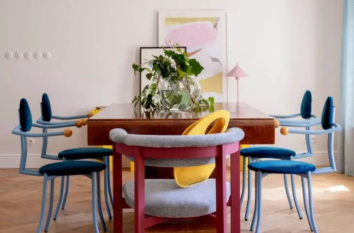 A massive table balances the playful forms of the chairs
