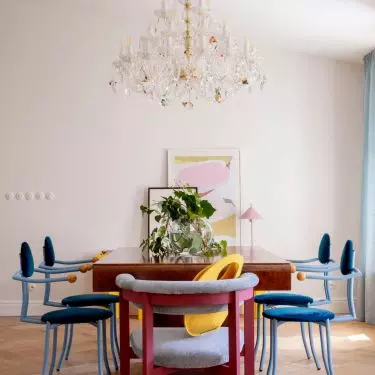 A massive table balances the playful forms of the chairs