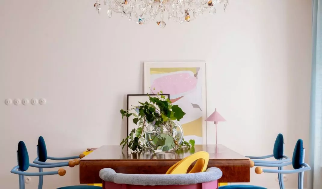 A massive table balances the playful forms of the chairs