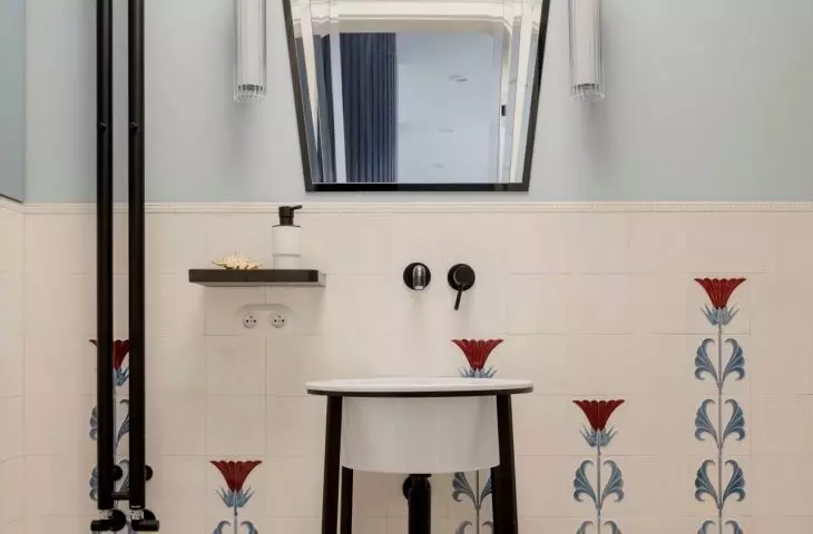 The bathroom uses tiles with a decorative floral motif
