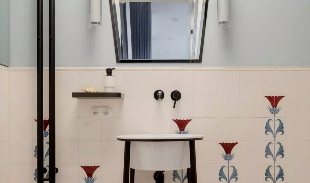 The bathroom uses tiles with a decorative floral motif