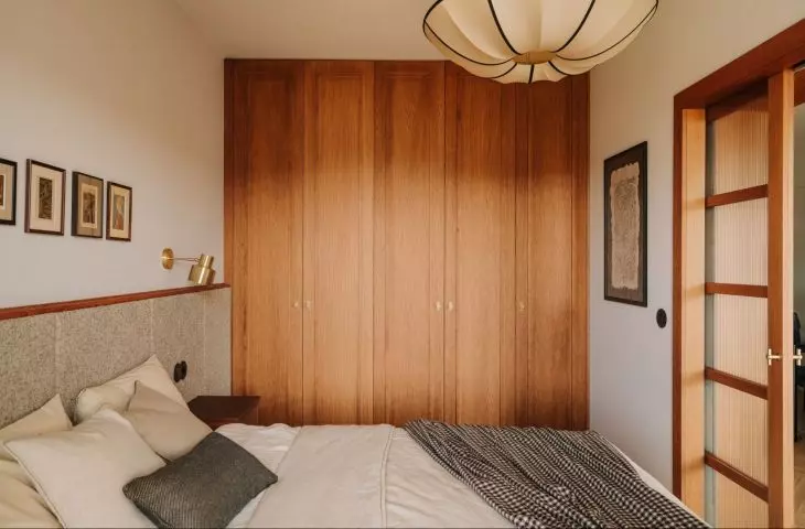 Bedroom with oak closet and soft green headboard