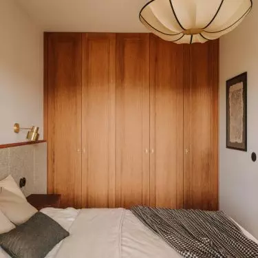 Bedroom with oak closet and soft green headboard