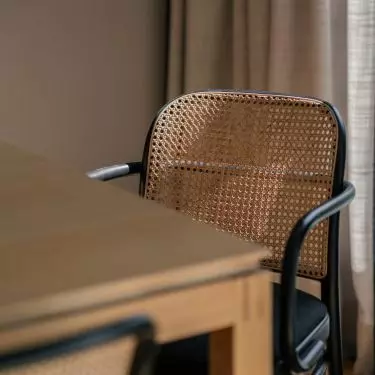 It is surrounded by black chairs with the characteristic Viennese plaid