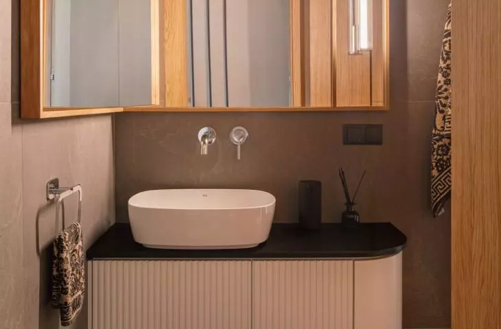 The sink cabinet features delicate grooves and a subtly rounded front