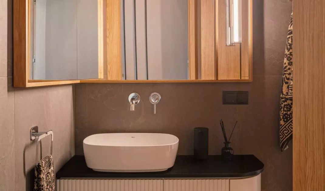 The sink cabinet features delicate grooves and a subtly rounded front