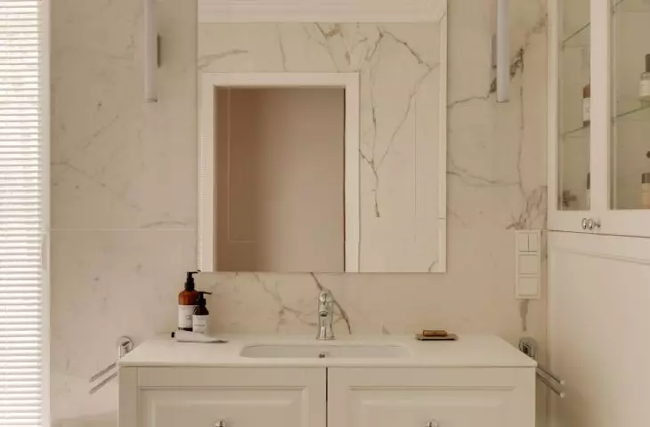 The walls of the bathroom are covered with tiles with a natural stone motif