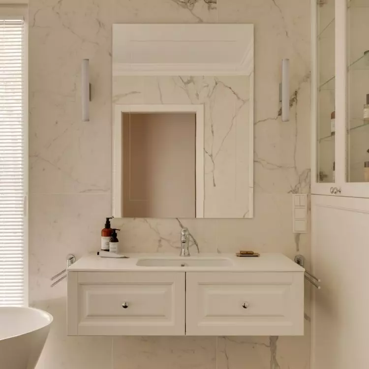 The walls of the bathroom are covered with tiles with a natural stone motif