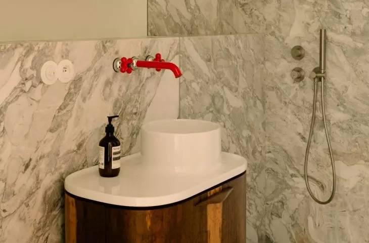 A characteristic element of the bathroom design is the red tap