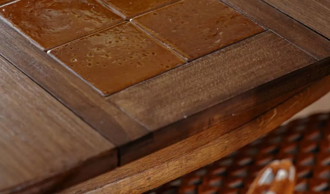 The table incorporates a ceramic insert made of floor tiles