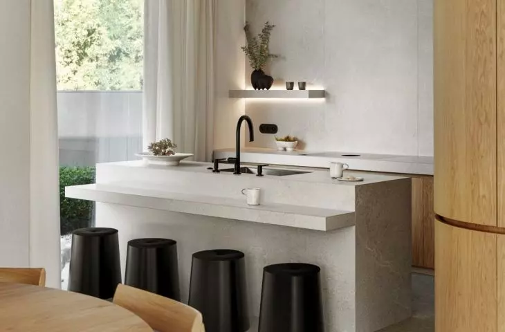 Rounded hockers contrast with the sharp lines of the kitchen island