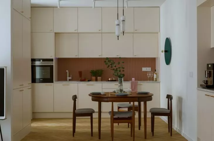 The kitchen combines light-colored cabinets with brick tiles to create a contrast 