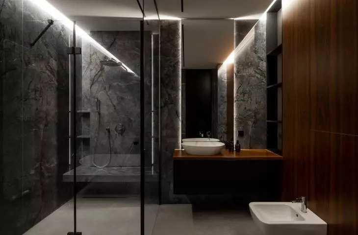 Modern bathroom with black fixtures, marble walls and wooden countertop is a luxurious bathing space in the spirit of contemporary elegance
