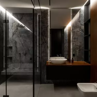 Modern bathroom with black fixtures, marble walls and wooden countertop is a luxurious bathing space in the spirit of contemporary elegance