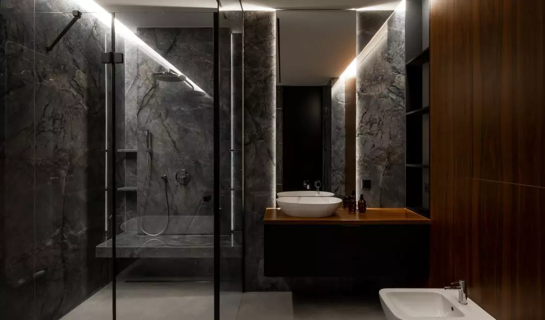 Modern bathroom with black fixtures, marble walls and wooden countertop is a luxurious bathing space in the spirit of contemporary elegance