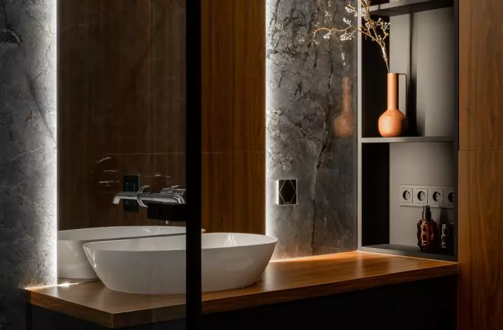 Bathroom harmoniously combines black marble with dark wood 