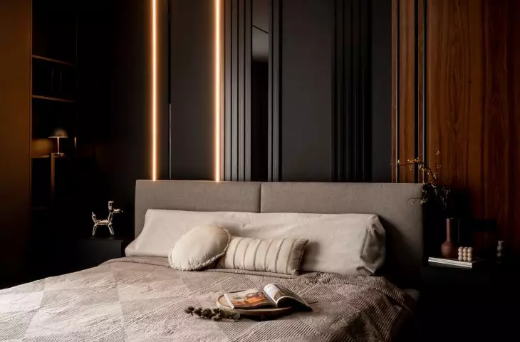 Elegant bedroom in dark colors with backlit LED strips and built-in cabinets is a combination of coziness and modern minimalism