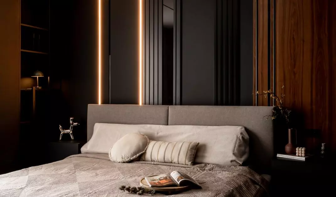 Elegant bedroom in dark colors with backlit LED strips and built-in cabinets is a combination of coziness and modern minimalism