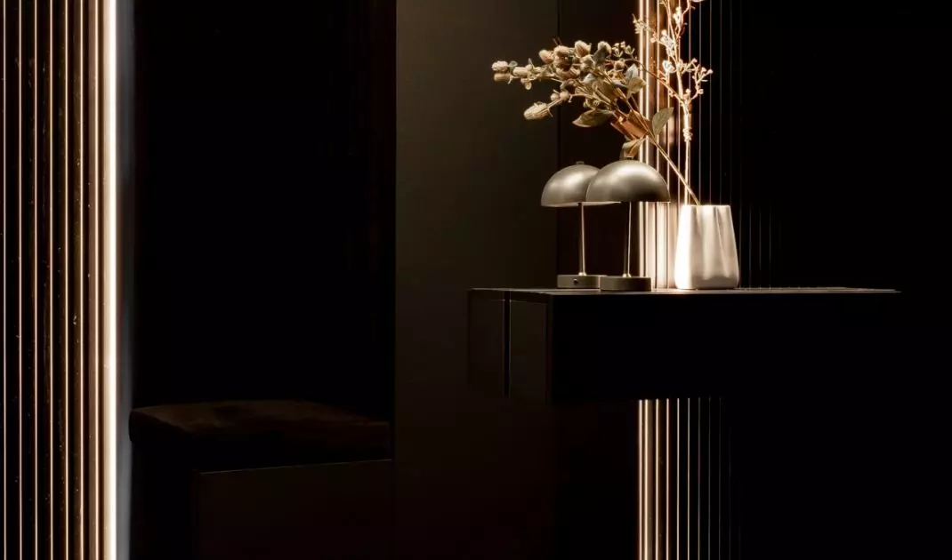 A mirrored wall in a narrow hallway optically enlarges the space, giving it a light and modern feel