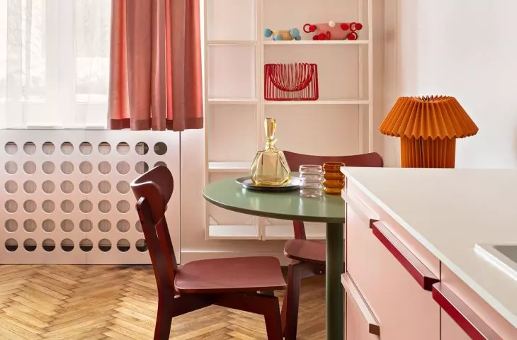 The green table is complemented by red chairs