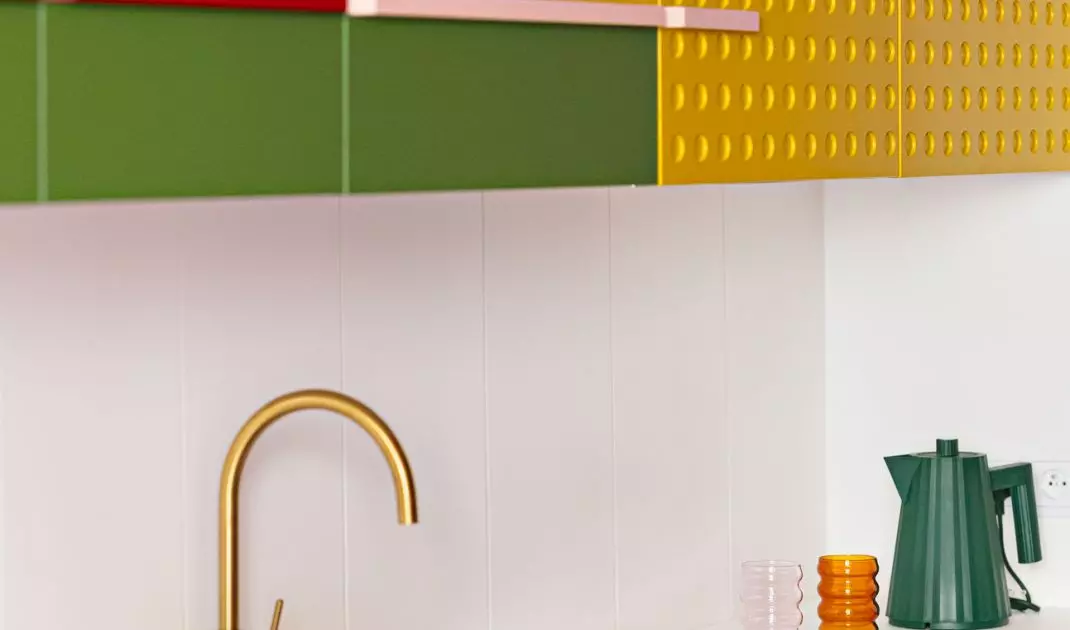 The upper cabinets surprise with a bold palette: from yellow, to green, to dark raspberry