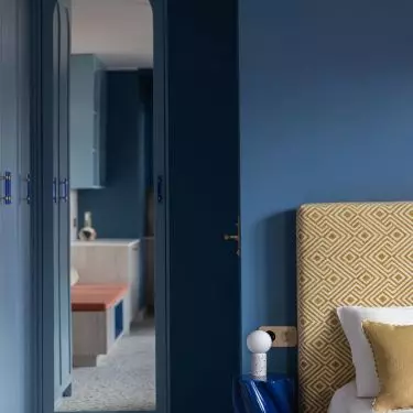 Behind the bedroom area is a small bathroom
