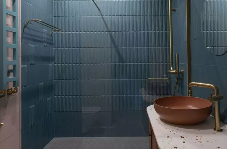 The walls of the shower have been tiled with convex tiles