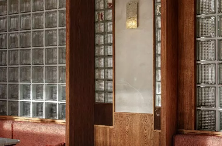 w ścianie z luksferów ulokowany jest drewniany portal prowadzący do ukrytej restauracji
