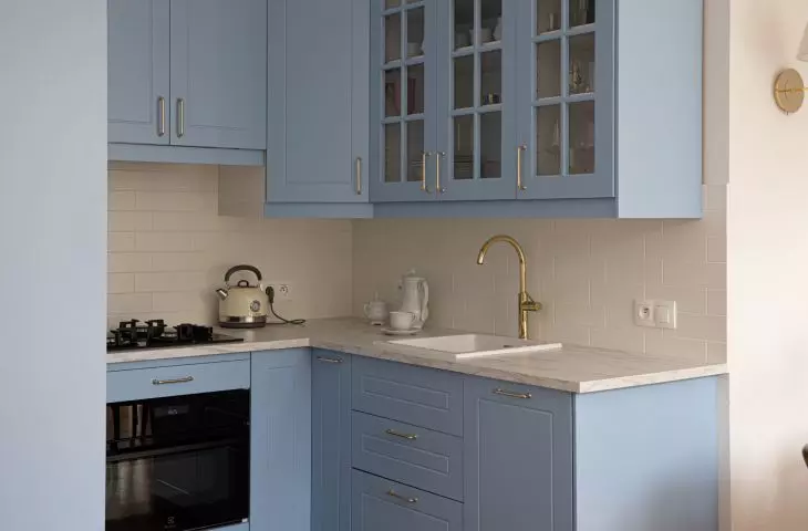 The kitchen is dominated by blue, which is complemented by gold accents 