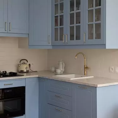 The kitchen is dominated by blue, which is complemented by gold accents