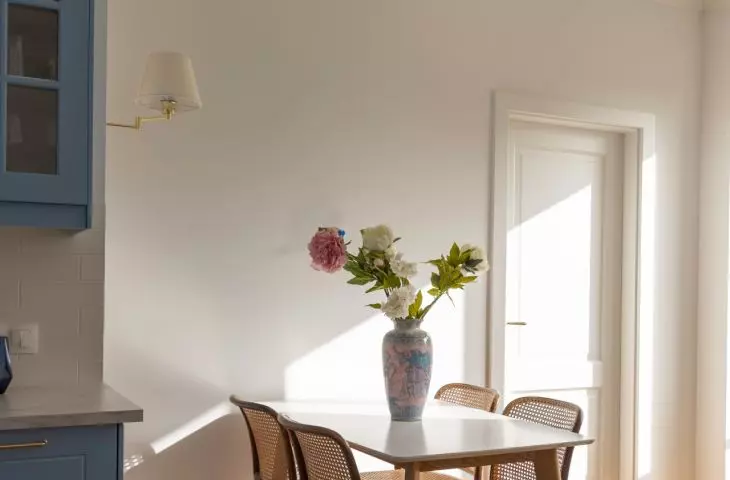 A wooden table and four chairs with woven seats were set in the dining room