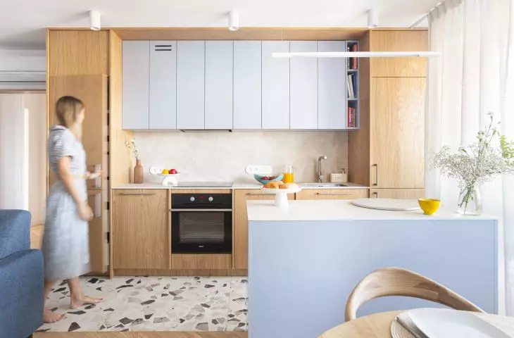 The kitchen island separates the annex from the dining room and living room. Light wood, beige accessories and blues inspired by the coastal landscape give the interior a cozy and light feel.