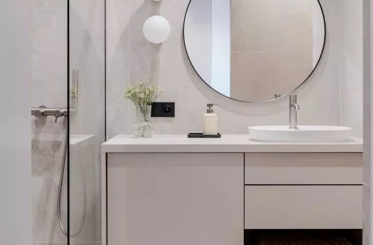 The bathroom, kept in light tones, with large tiles in a subtle marble pattern, impresses with its simplicity and class