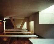 The juxtaposition of a cool concrete structure with the warmth of wooden panels - a contrast of materials that builds the atmosphere of the interiors