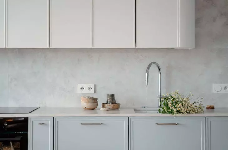 Upper cabinets in a smooth white high-gloss finish emphasize the modern character and optically enlarge the space